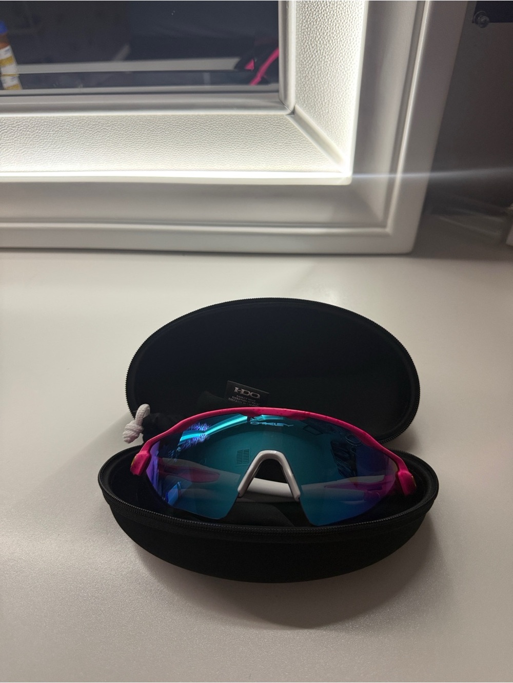 Oakley Pink Frame Sunglasses with Blue Mirrored Lenses and White Nose Pad